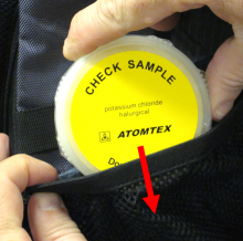 Close-up view of check sample KCl Potassium being placed in side pocket of Atomtex backpack