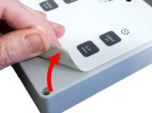Overlay lifted by hand at corner of label
