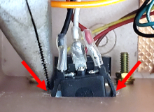 Plastic tabs that lock the charging port into place are pressed towards the body of the charging port.