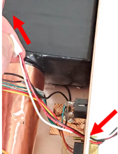 The white connector for the new charging port is fed into the detector through the charging port hole.